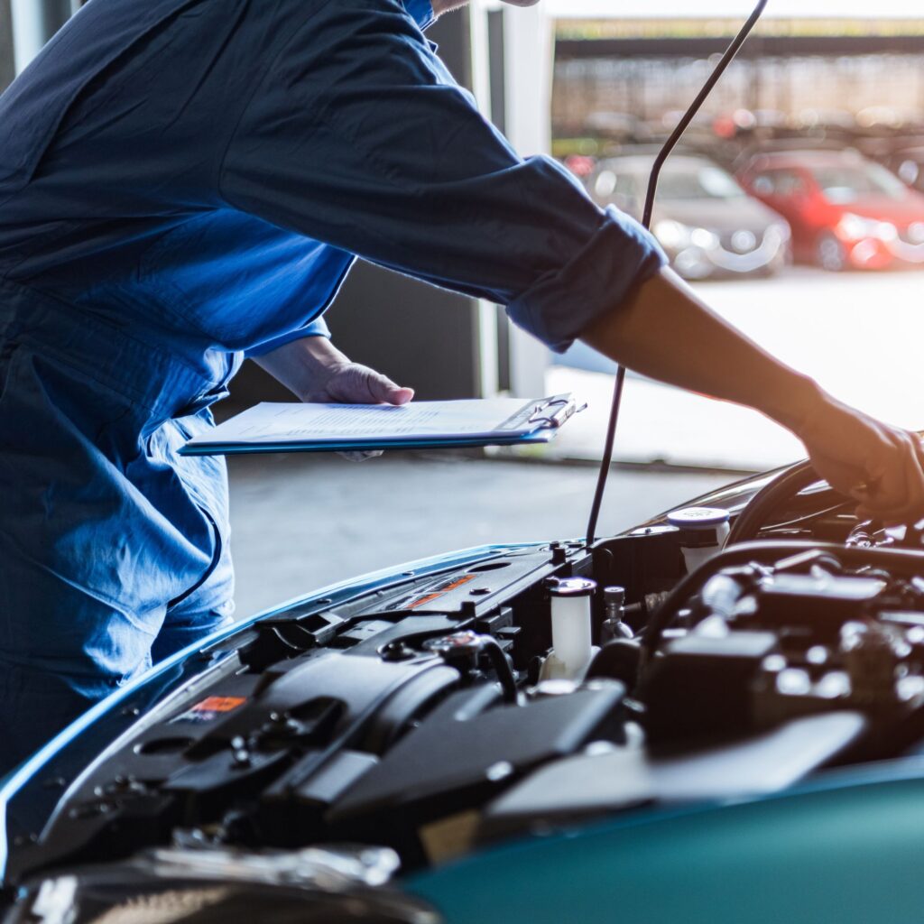 mechanic working beneath the hood of a car